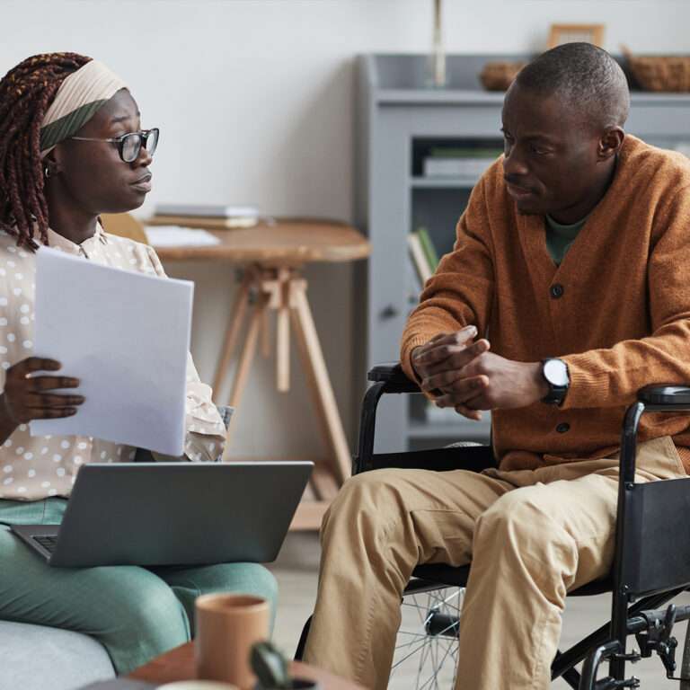 Two people talking, one person in a wheelchair