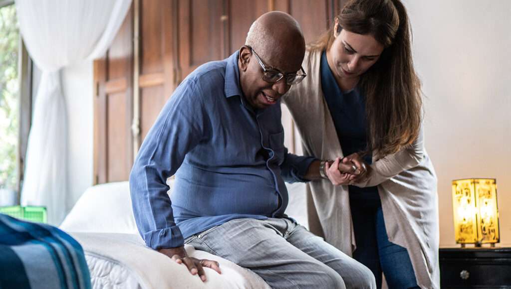 Woman helping elderly man in home
