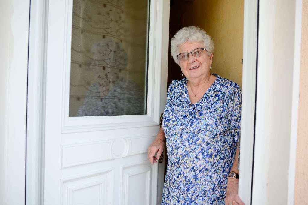 Older adult woman standing at door 