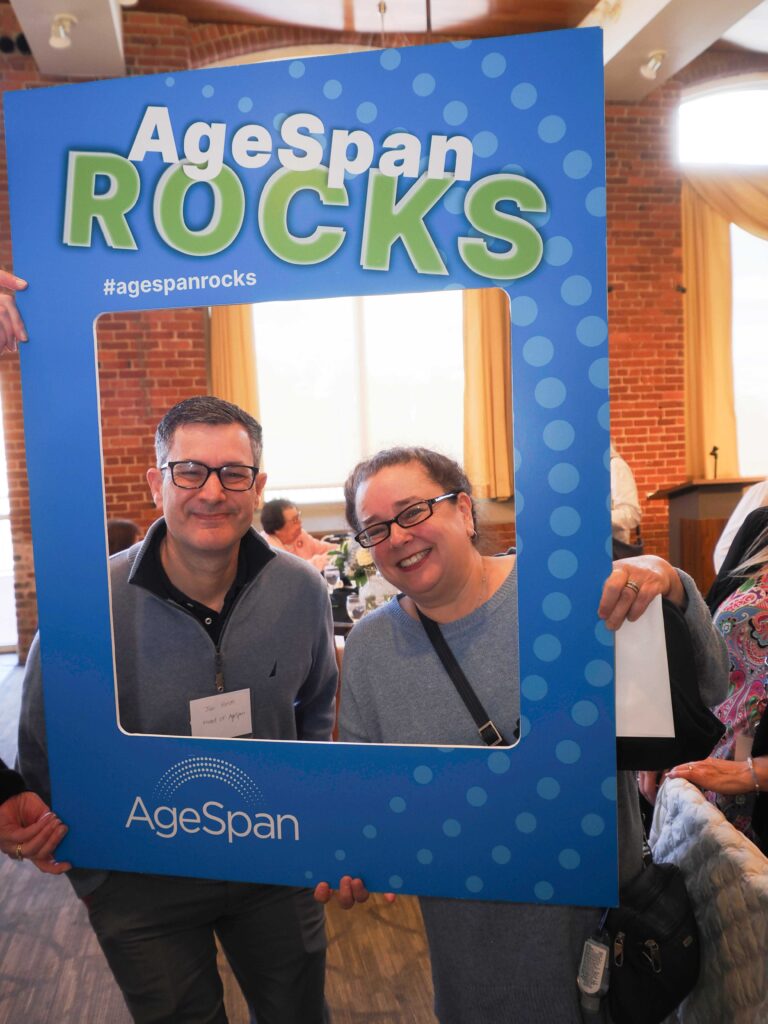 Two people pose in AgeSpan rocks frame