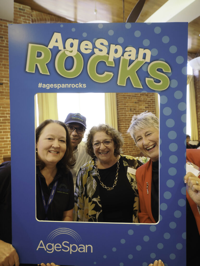Joan Hatem-Roy, Jen Raymond, Bonnie Sisson, Jim Santiago pose in AgeSpan rocks frame