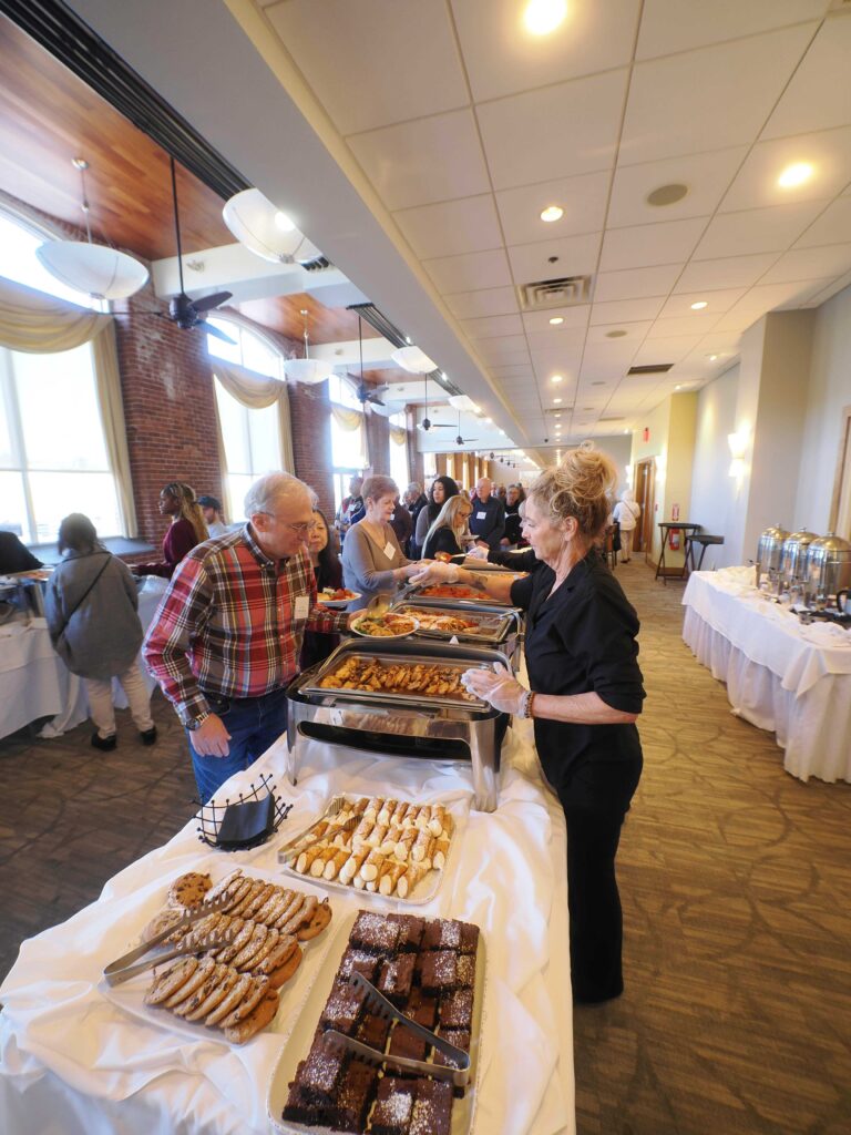Food server hands volunteer plate of food