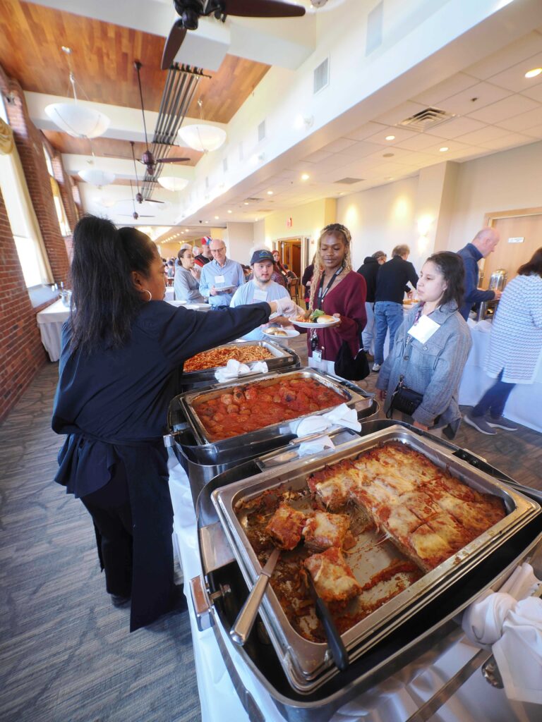 Food server hands volunteer plate of food
