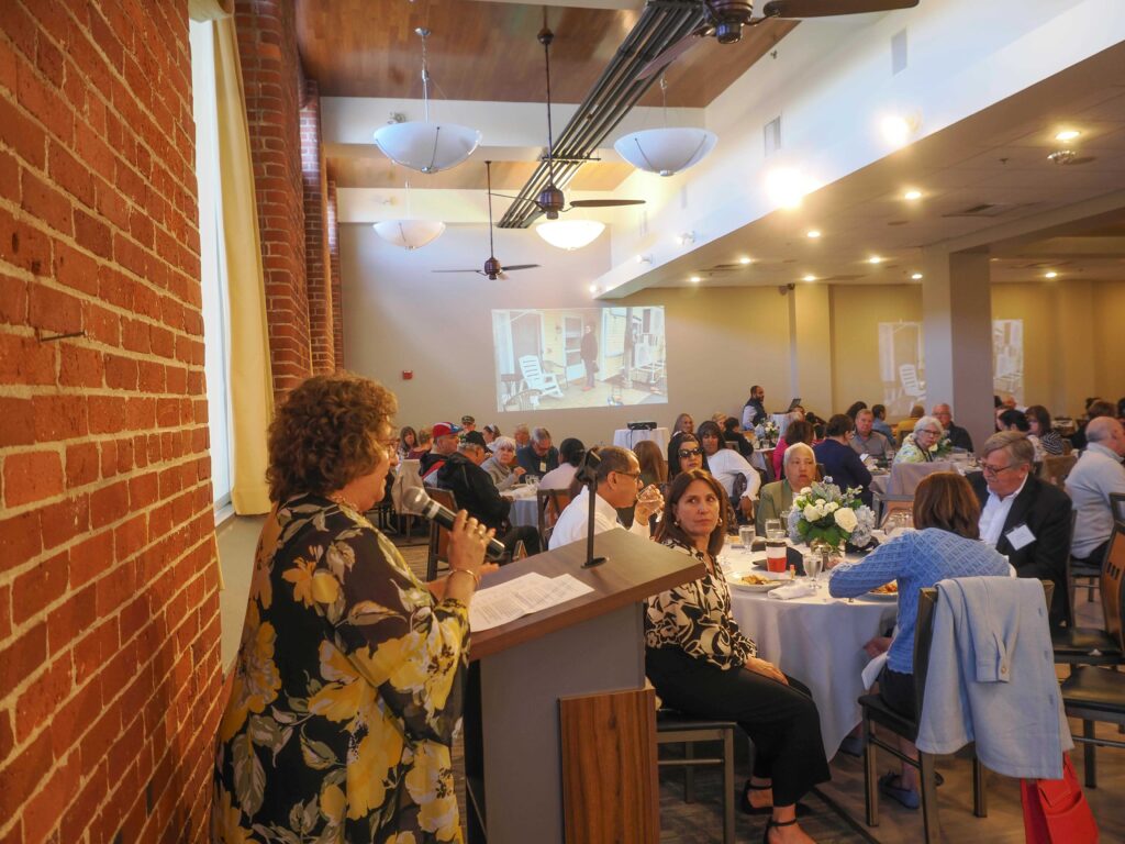 Joan Hatem-Roy addresses room full of volunteers