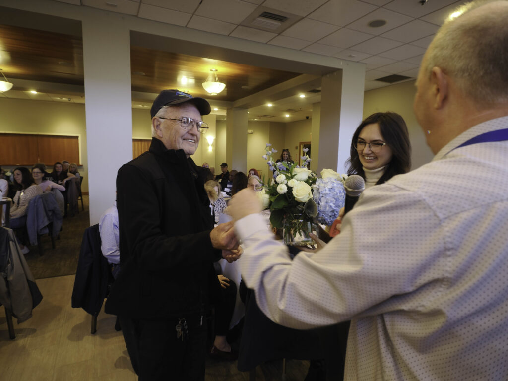 Volunteer in AgeSpan hat wins flower arrangement