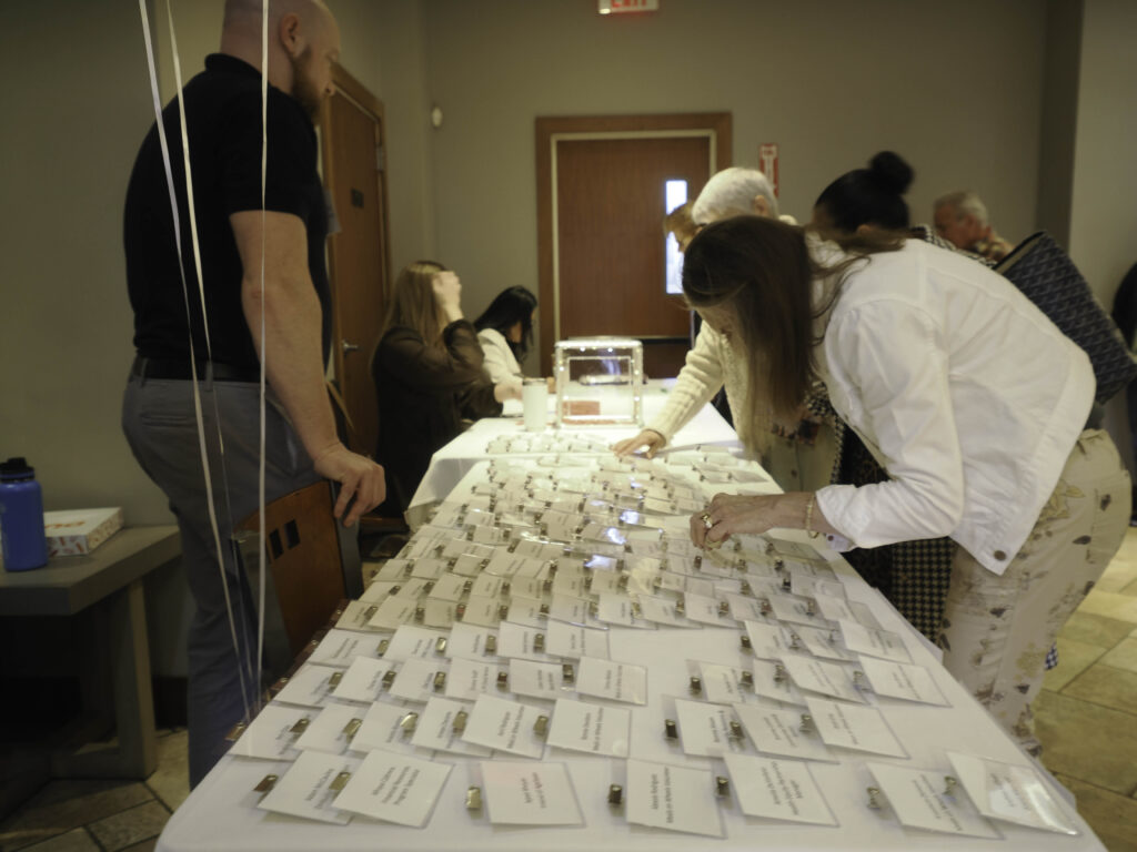 Woman chooses from nametags on a table.